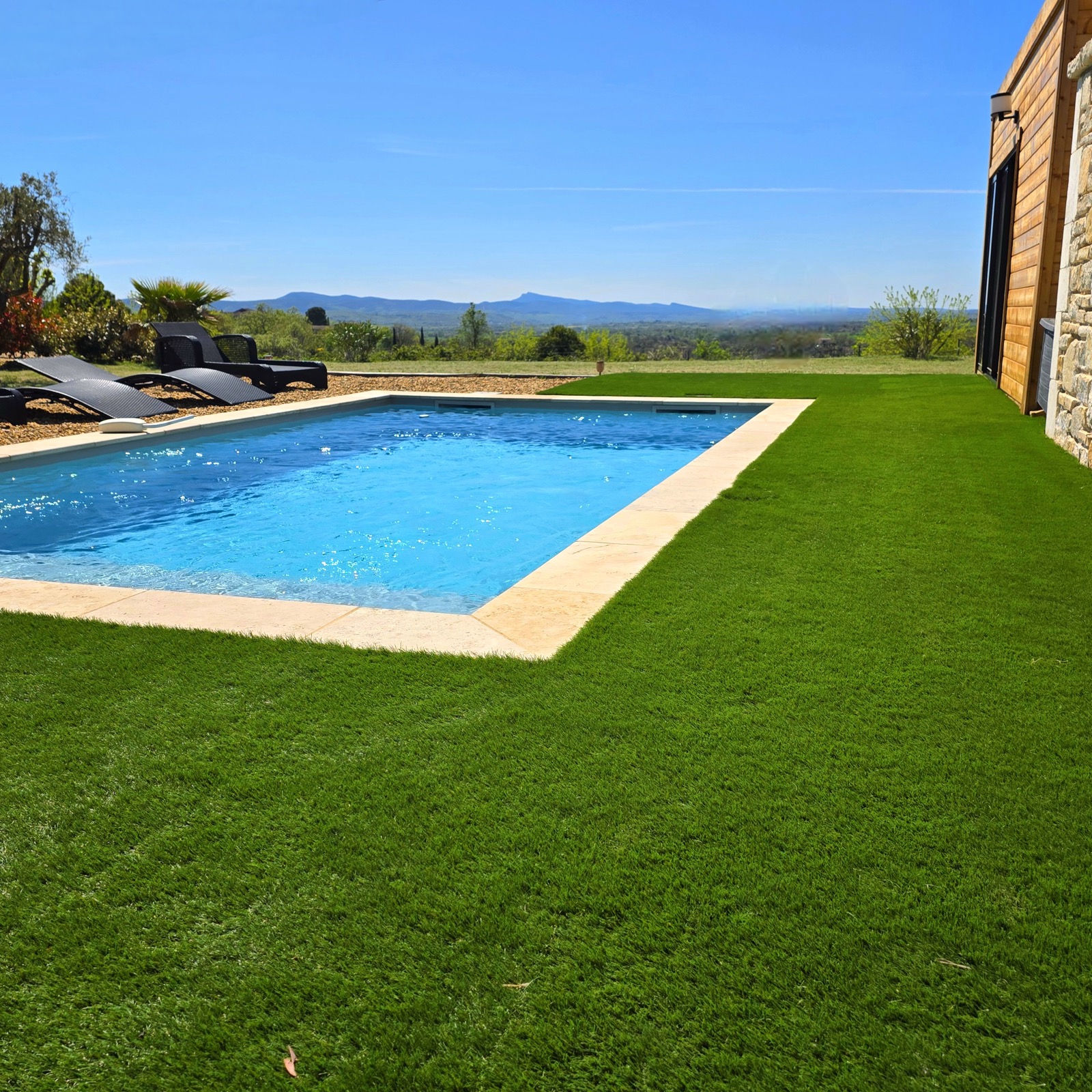 Swimming pool with sun loungers and panoramic mountain view